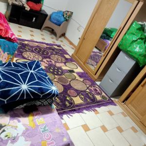 een kamer met een tapijt en een paraplu op de vloer bij بيت الطالبات والمغتربات in Zes oktober (stad)