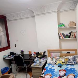 een slaapkamer met een bed, een bureau en een tafel bij بيت الطالبات والمغتربات in Zes oktober (stad)