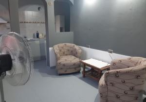 a room with two chairs and a fan and a table at Dpto en San Antonio Oeste 3 pax in San Antonio Oeste