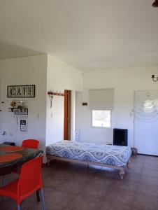a bedroom with a bed and a table and a television at Loft Las Acacias in Potrero de los Funes
