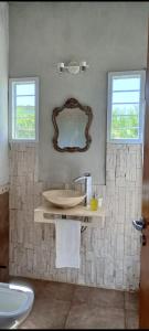 uma casa de banho com um lavatório e um espelho na parede em Loft Las Acacias em Potrero de los Funes