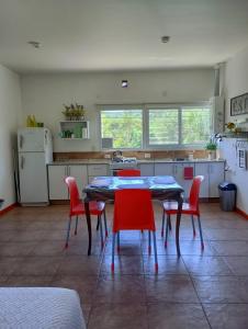 a kitchen with a table and red chairs at Loft Las Acacias in Potrero de los Funes