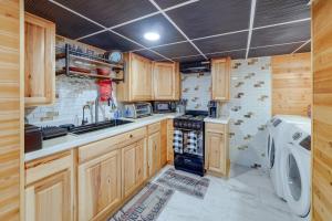 een keuken met houten kasten en een wasmachine en droger bij Beckley Studio with Private Hot Tub and Home Gym! in Beckley