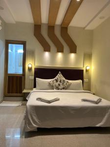 sypialnia z dużym łóżkiem z białą pościelą w obiekcie Max Guest House w mieście Agra