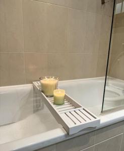 dos velas sentadas en una bandeja en una bañera en Mediacity studio apartment Salford-quays, en Mánchester