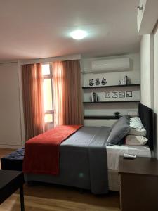 a bedroom with a bed with a red blanket at Flat em Brasília - Park Sul in Brasilia