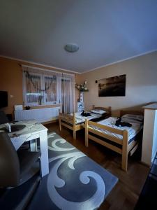 ein Wohnzimmer mit 2 Betten und einem Tisch in der Unterkunft Apartman B&S Apatin in Apatin