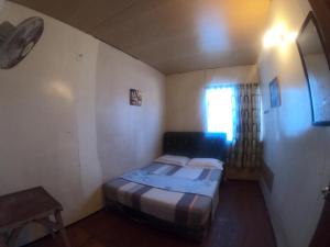a small bedroom with a bed and a window at Mabul Backpackers in Pulau Mabul 