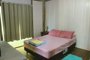 Casa rústica pertinho das águas في سانتو أمارو دا إمبيراتريز: غرفة نوم عليها سرير وفوط