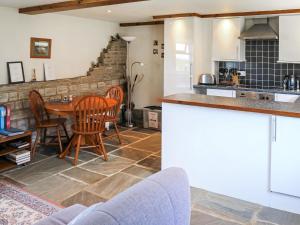 a kitchen and dining room with a table and chairs at The Byre in Broom