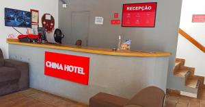 a cnm hotel reception desk with a red sign at China Hotel in Canindé de São Francisco