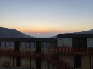 a view of the sunset from the balcony of a building at Dana’s Trail Hotel in Dana