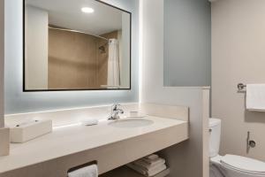 a white bathroom with a sink and a mirror at Courtyard by Marriott San Jose Airport Alajuela in Alajuela City