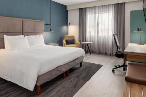 a hotel room with a large bed and a desk at Courtyard by Marriott San Jose Airport Alajuela in Alajuela City