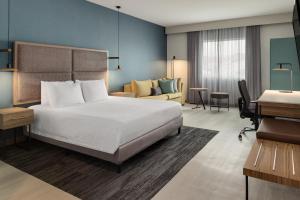 a hotel room with a bed and a desk at Courtyard by Marriott San Jose Airport Alajuela in Alajuela City