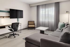 a living room with a couch and a desk at Courtyard by Marriott San Jose Airport Alajuela in Alajuela City
