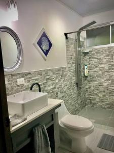 a bathroom with a sink and a toilet and a shower at Cabaña Río Blanco Guapiles Costa Rica in Guápiles