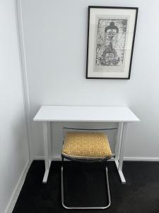 a white table with a chair under it at Swan Guest House in Brisbane