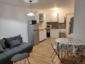 a living room with a couch and a table and a kitchen at Charmant appartement à 25 minutes de Paris. in Argenteuil