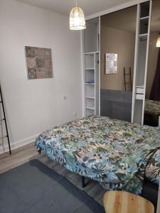 um quarto com uma cama com uma colcha em Charmant appartement à 25 minutes de Paris. em Argenteuil