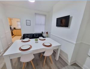 a white table and chairs in a living room at Anfield 5 minutes walk sleeps 10 in Liverpool