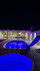 una gran piscina azul en un patio por la noche en Piscina, barbacoa y casa en Rivera