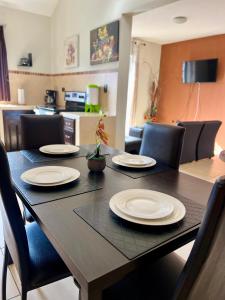 una mesa de comedor con platos blancos. en Amplio Apartamento, en Colonia Cerezos, Tercer nivel en Quetzaltenango