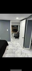 Lovely Private 1-bedroom with free parking في واشنطن: غرفة نوم مع أرضية بلاط مع باب وأريكة