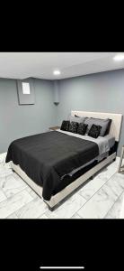 Lovely Private 1-bedroom with free parking في واشنطن: غرفة نوم بسرير كبير مع شراشف سوداء