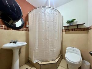 een badkamer met een douche, een toilet en een wastafel bij Amplio Apartamento, en Colonia Cerezos, Tercer nivel in Quetzaltenango