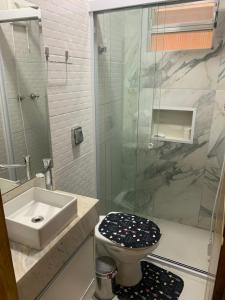 a bathroom with a toilet and a sink and a shower at Casa com churrasqueira Guilhermina Praia Grande in Praia Grande