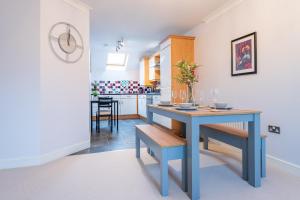 a kitchen with a blue table and a dining room at 2 bedroom Apartment - Free secure parking - City Centre - Sleeps up to 5-6 in Exeter