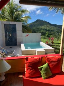 Un jacuzzi encima de un sofá rojo. en Case Oiseaux de paradis avec piscine, en Sainte-Rose