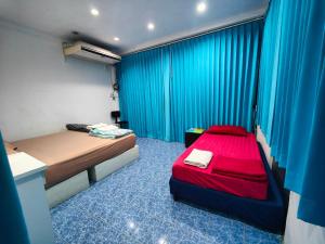 Habitación pequeña con cama y cortinas azules en Phangan Hostel Haadrin Homestay, en Haad Rin