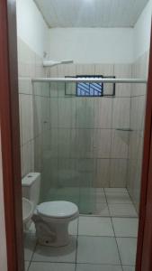 een badkamer met een toilet en een glazen douche bij APARTAMENTO CAUAMÉ in Boa Vista