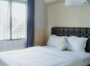 CikundulにあるVilla Kota Bunga EE2-03のベッド(黒いヘッドボード、白い枕付)