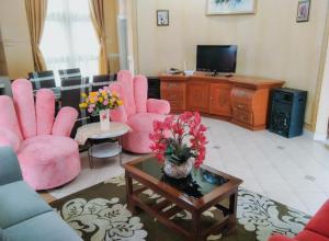 CikundulにあるVilla Kota Bunga EE2-03のリビングルーム(ピンクの椅子、テレビ付)