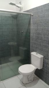een badkamer met een toilet en een glazen douche bij APARTAMENTO CAUAMÉ in Boa Vista