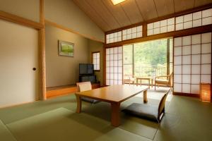 een kamer met een tafel en stoelen en een raam bij Kyukamura Oku-Musashi in Hanno