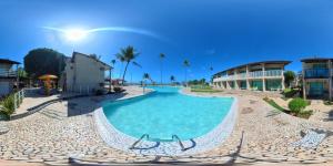 a swimming pool in the middle of a resort at Chale 48 Maragogi Village Gales in Maragogi