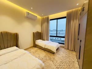 una camera d'albergo con due letti e una finestra di REMAZ ROSE BOULEVARD a Riyad