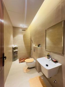 bagno con lavandino, servizi igienici e specchio di REMAZ ROSE BOULEVARD a Riyad