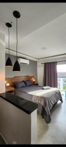 um quarto com uma cama e duas luzes pendentes em Studio RD em Angra dos Reis