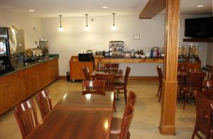 un restaurant avec une table et des chaises ainsi qu'une cuisine dans l'établissement Country Inn & Suites by Radisson, Winnipeg, MB, à Winnipeg