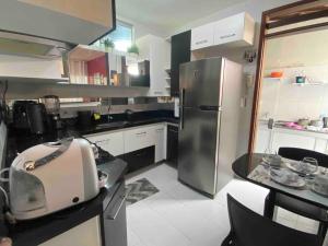 a kitchen with a stainless steel refrigerator and a mixer at Duplex em condomínio fechado in Campina Grande