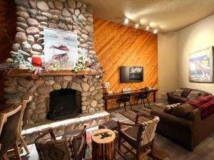 a living room with a large stone fireplace at Whitetail Lodge in Saint Germain