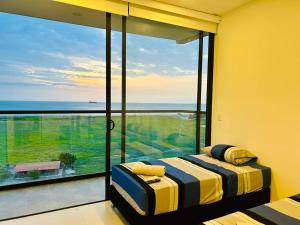 a bedroom with a large window with a view of the ocean at Salinas Del Mar - Pozos Colorados - By INMOBILIARIA VS in Santa Marta