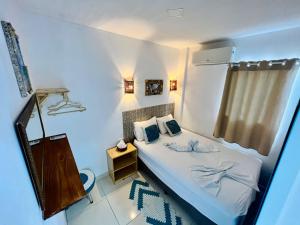 a small bedroom with a bed and a window at Flats Corais in Maragogi