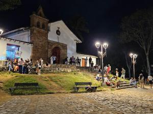 un grupo de personas sentadas fuera de una iglesia por la noche en Casa Alba en Cali