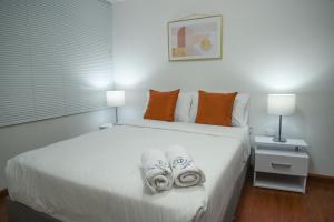 een slaapkamer met een wit bed en handdoeken bij Cozy Place in Bogota